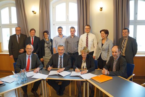 Gruppenbild: Alle Teilnehmerinnen und Teilnehmer bei der Vertragsunterzeichnung